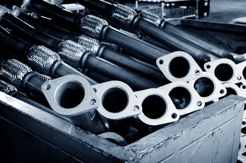 Automotive exhaust pipe assemblies with flanges, rigid tubing, and flexible sections